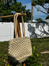 Natural Woven Tote Bag hanging outdoors, showcasing its handmade eco-friendly design and natural textures.