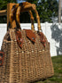 Bamboo Handle Woven Tote with stylish bamboo handles displayed outdoors, perfect for beach outings.