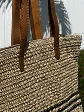 Coastal Stripe Woven Tote showcasing natural straw material and brown leather straps, ideal for beach and everyday use.