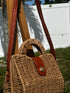 Mini Coastal Crossbody Bag showcasing its stylish woven design and chic leather strap against a sunny outdoor backdrop.